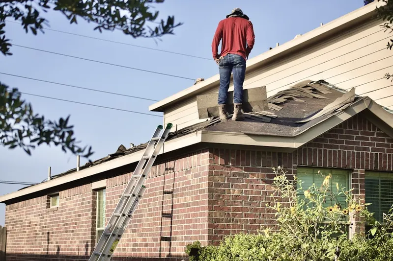 Professional roofer working on a residential roof in West Medford